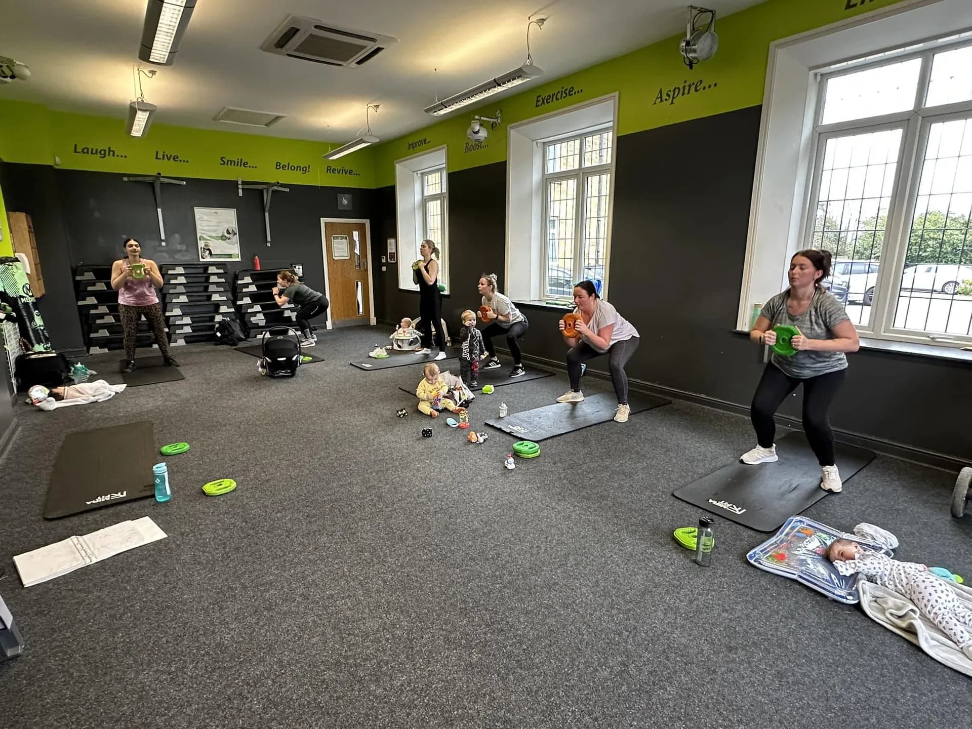 Mums working out together with their babies alongside them at a Mama & Me Fitness class